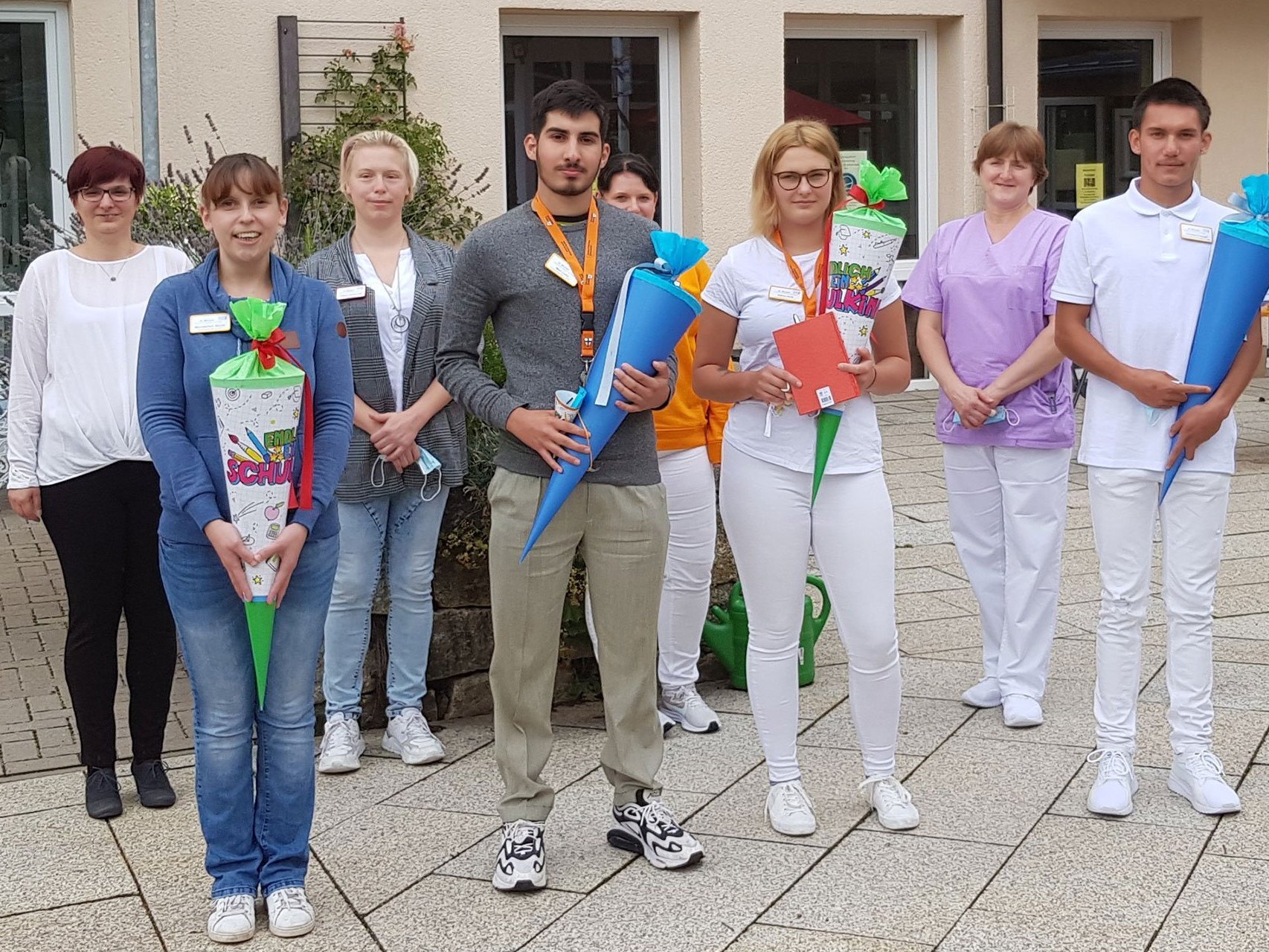 Gruppenfoto: Jugendliche stehen vor der Einrichtung und halten teilw. eine "Schultüte" 